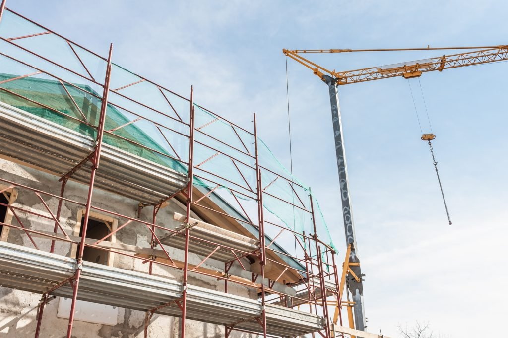 Building armor for house under restoration and crane.