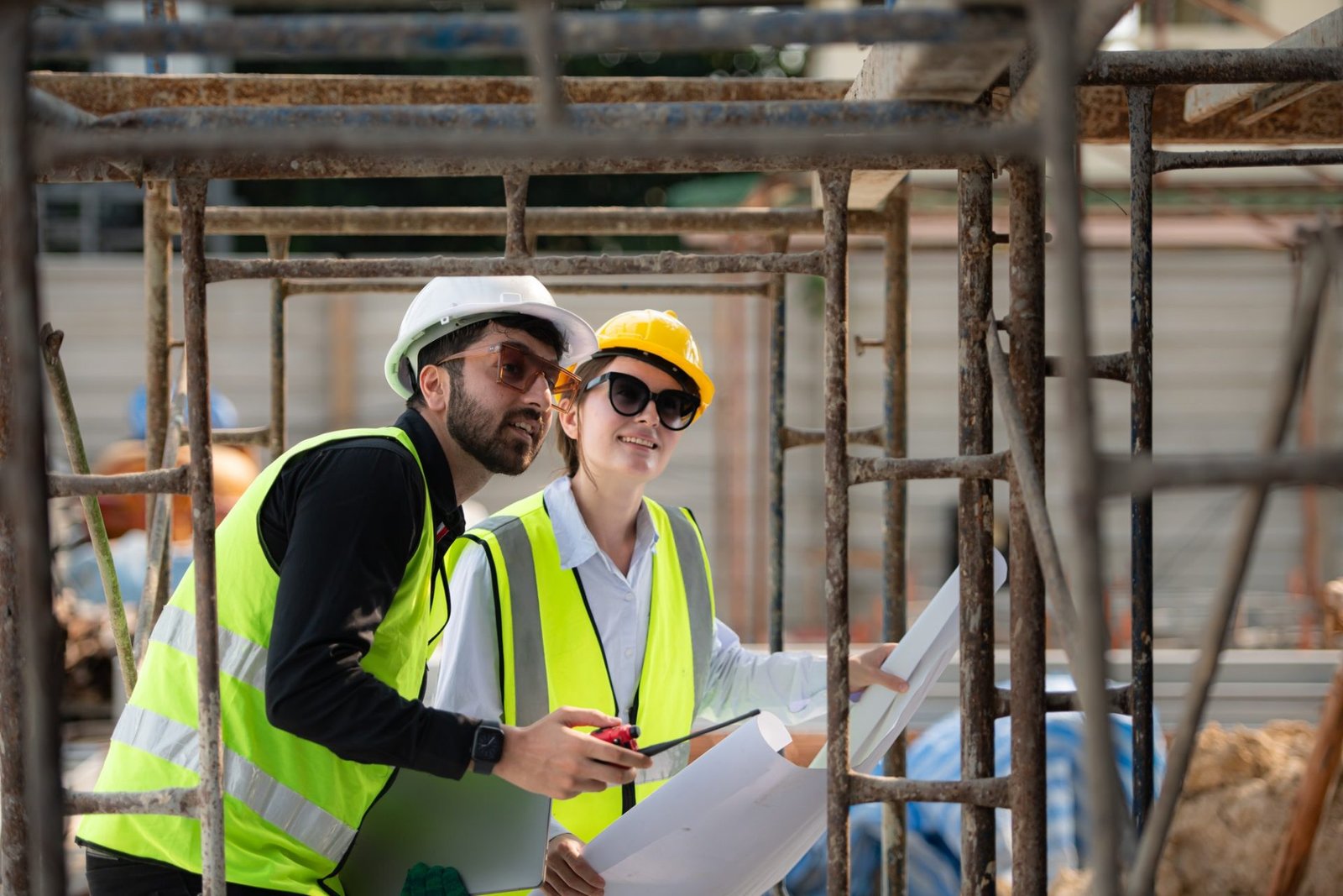 Engineer and architect working on the construction site, double-checking plans and process.