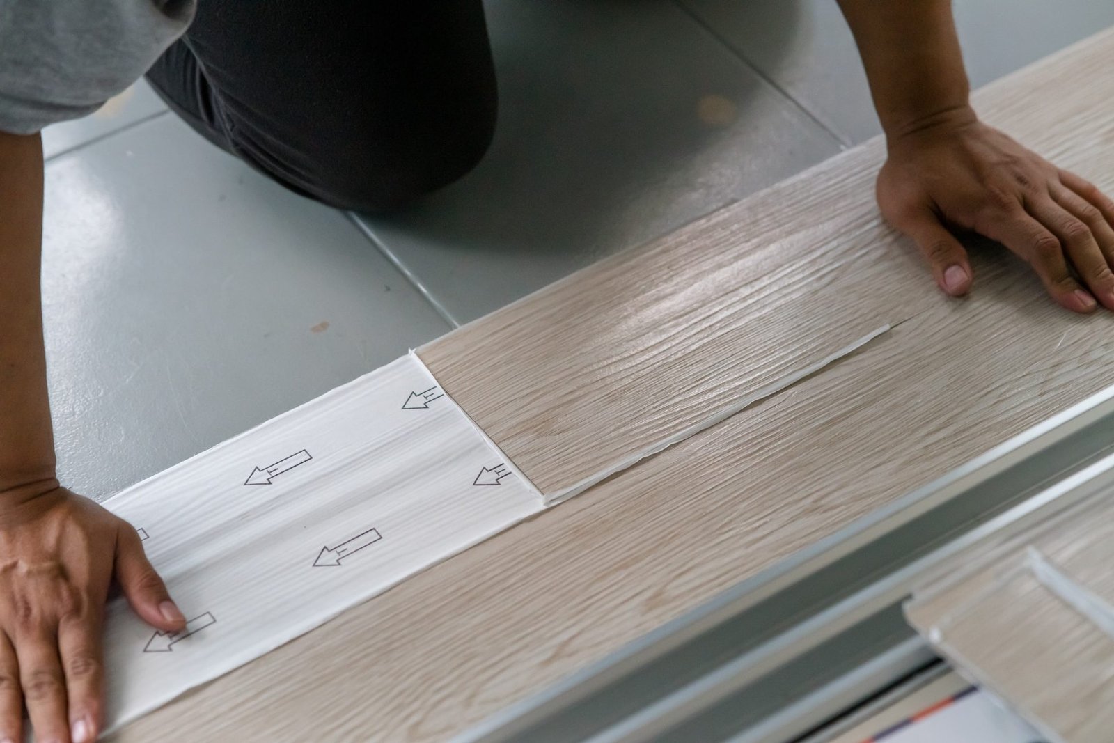 installing self adhesive vinyl flooring. man diy at home