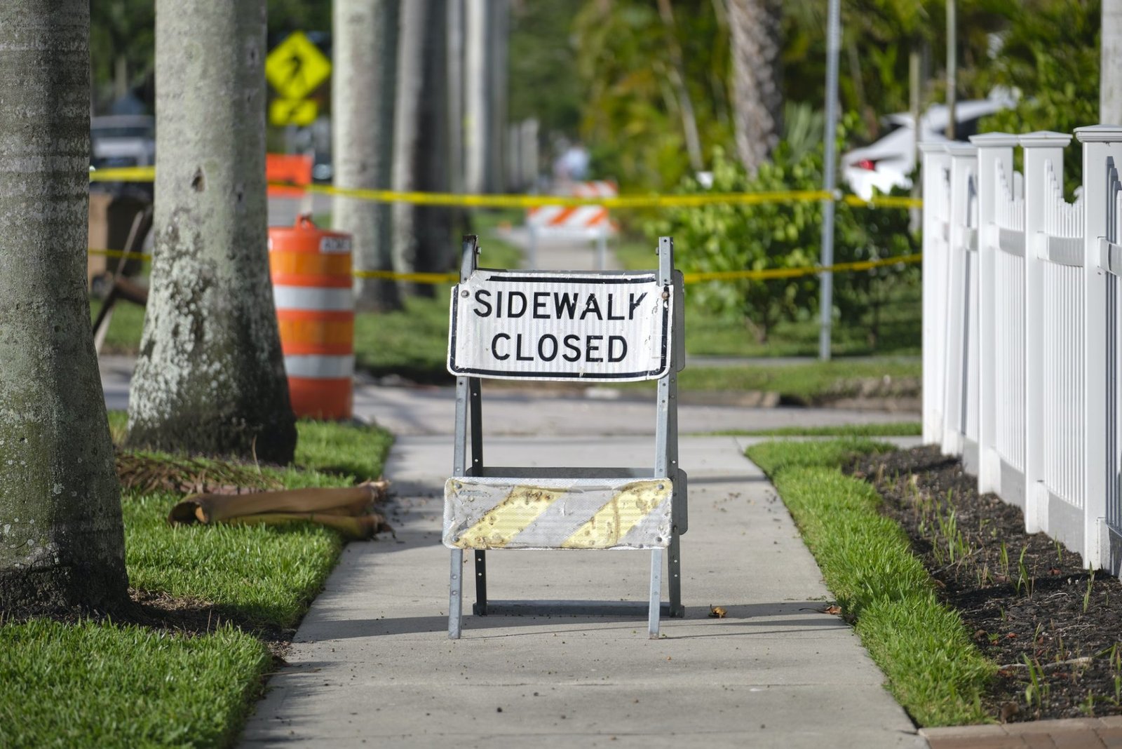 Warning sign that sidewalk is closed at street construction site. Utility work ahead