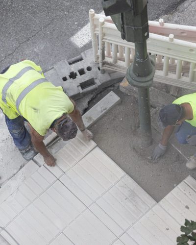 Construction workers repairing a sidewalk